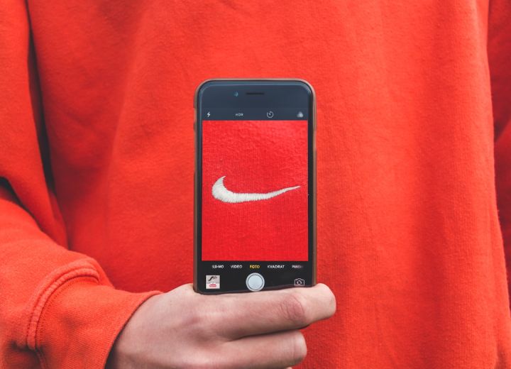 Brand - person holding iPhone taking picture on Nike label