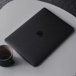 Brand - MacBook Pro beside mug on table