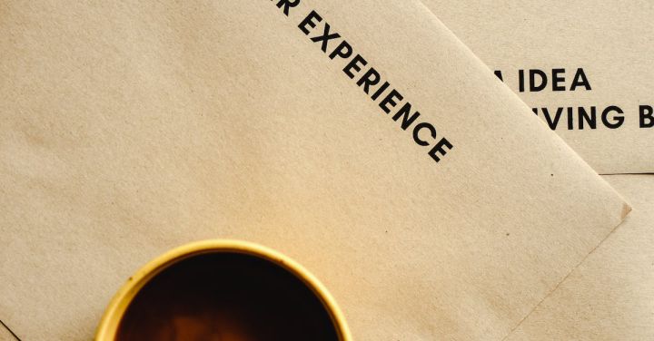 Customer Experience - A Top Shot of a Cup of Coffee on Brown Envelopes