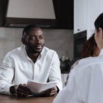 Corporate Social Responsibility - Afro-American Man and Caucasian Woman Having Meeting at Home with Social Worker